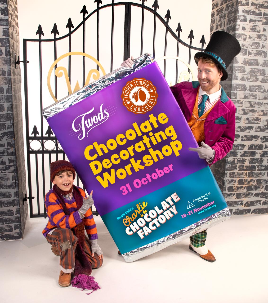 Willy Wonka and Charlie Bucket holding a large chocolate bar printed with the Chocolate Decorating Workshop and Charlie and the Chocolate Factory details